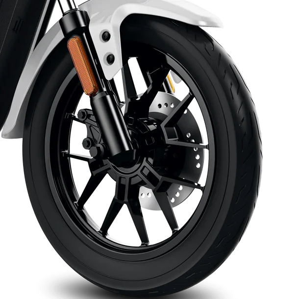 Close-up of a black motorcycle front wheel with a disc brake and white fender.