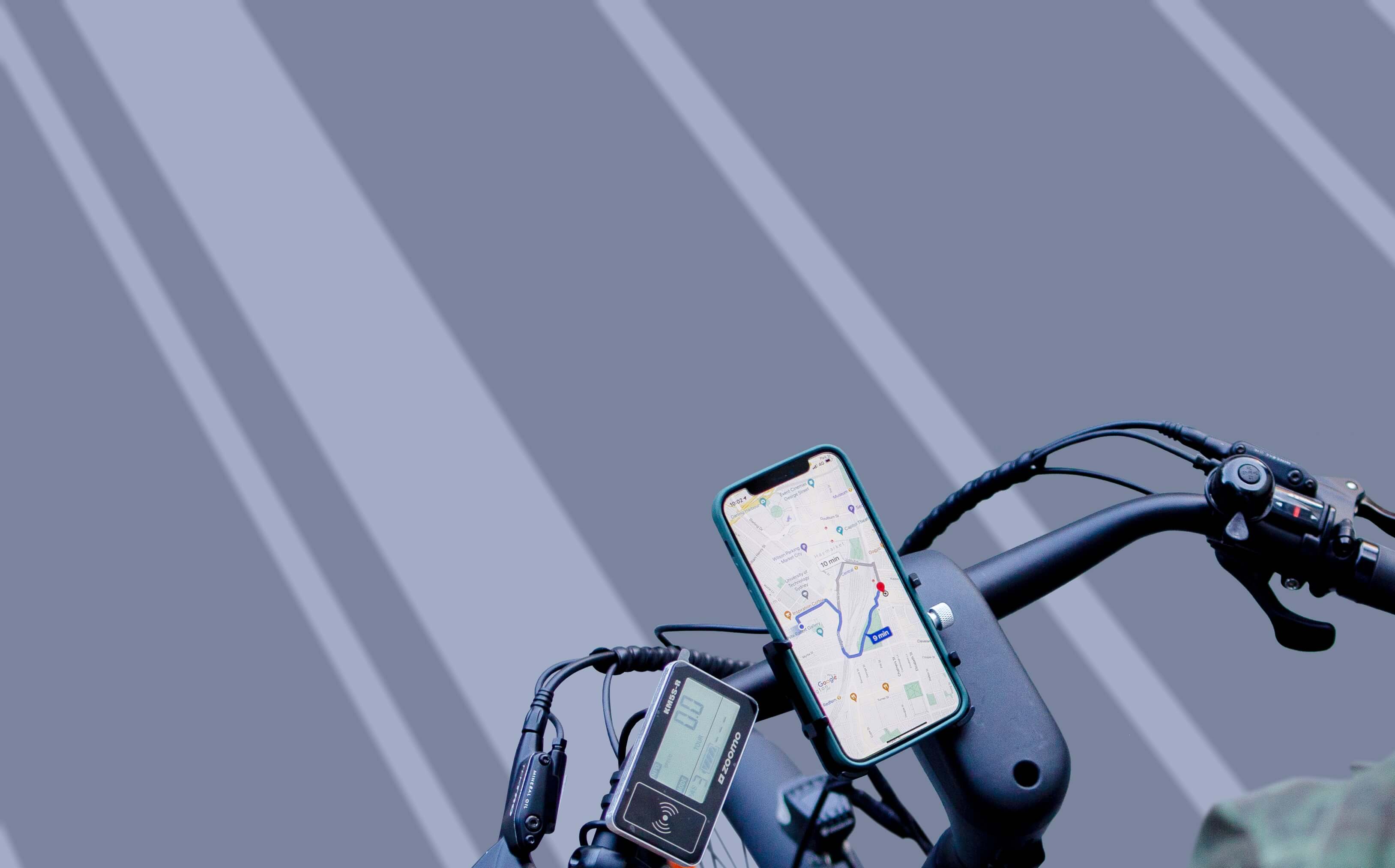 Smartphone on bike handlebar showing map with route and distance for navigation.