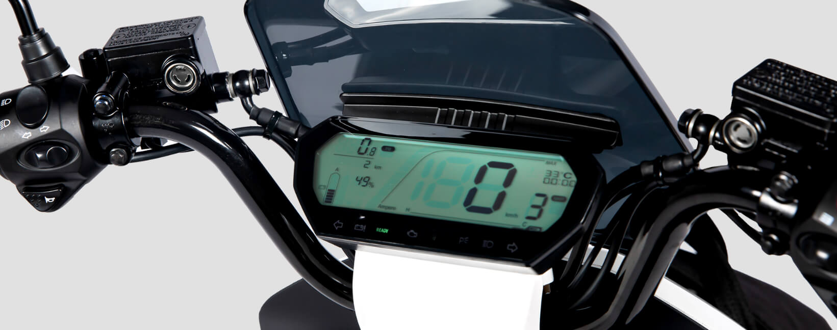 Close-up of an electric motorcycle's digital dashboard and handlebars with control switches.