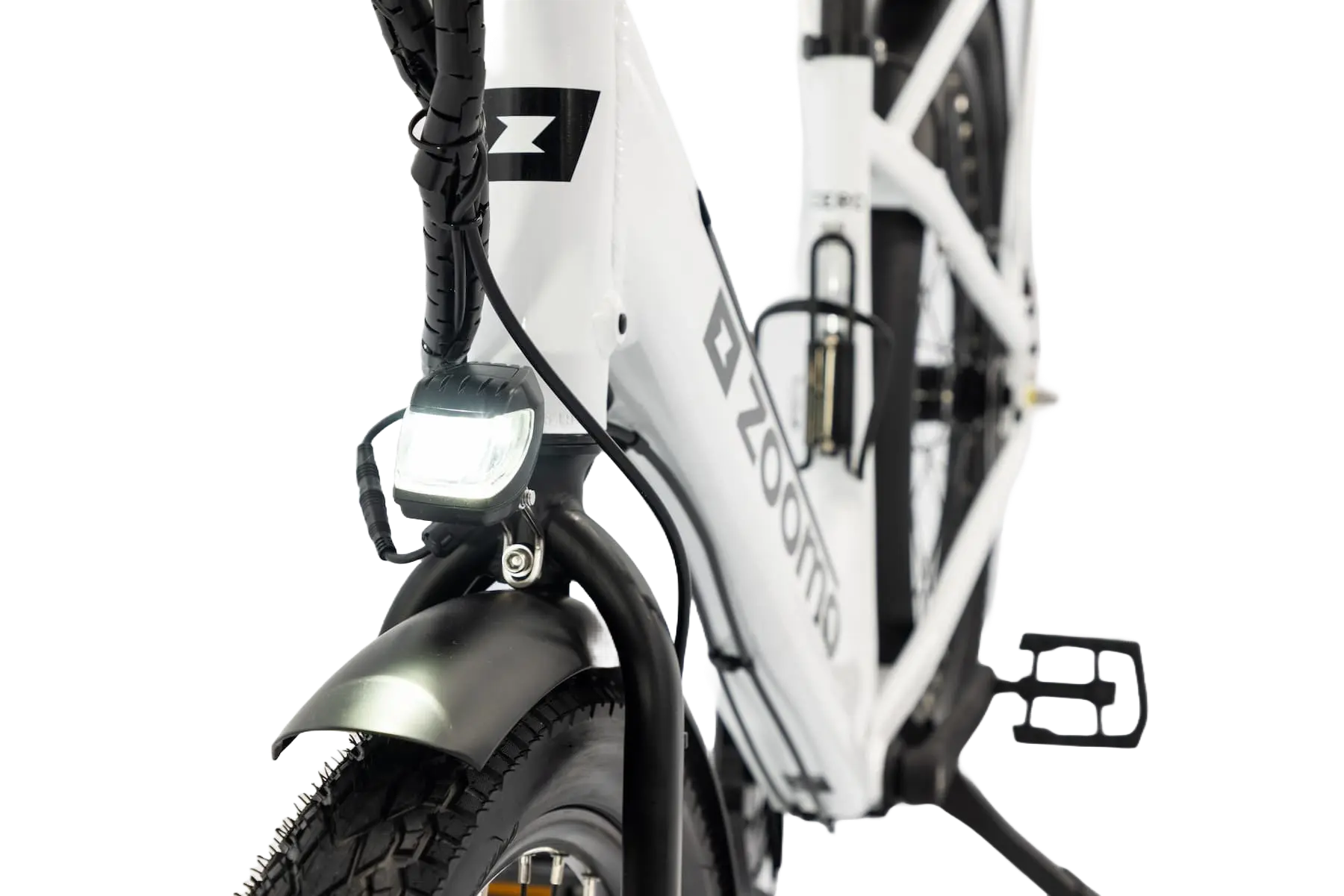 Close-up of a white Zoomo electric bike front wheel with tire, headlight, and fender.